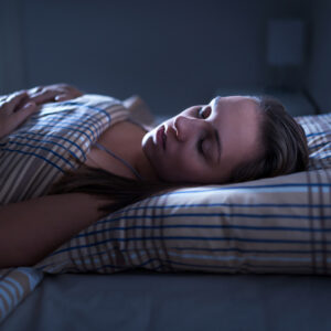 Woman sleeping restfully in a bed.