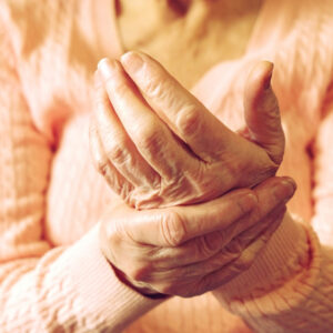 Eldery woman holding her hand in pain.