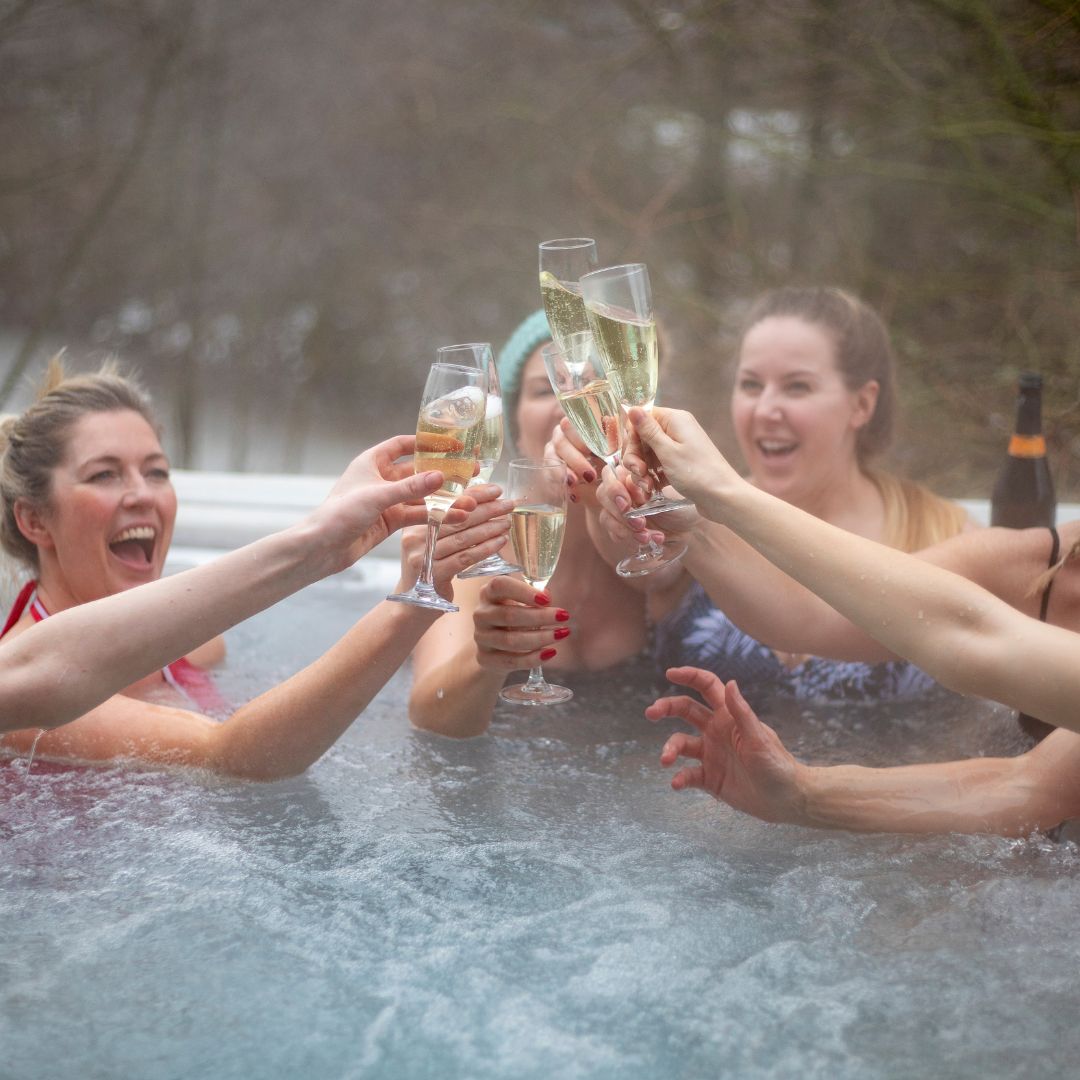 friends toasting in a hot tub
